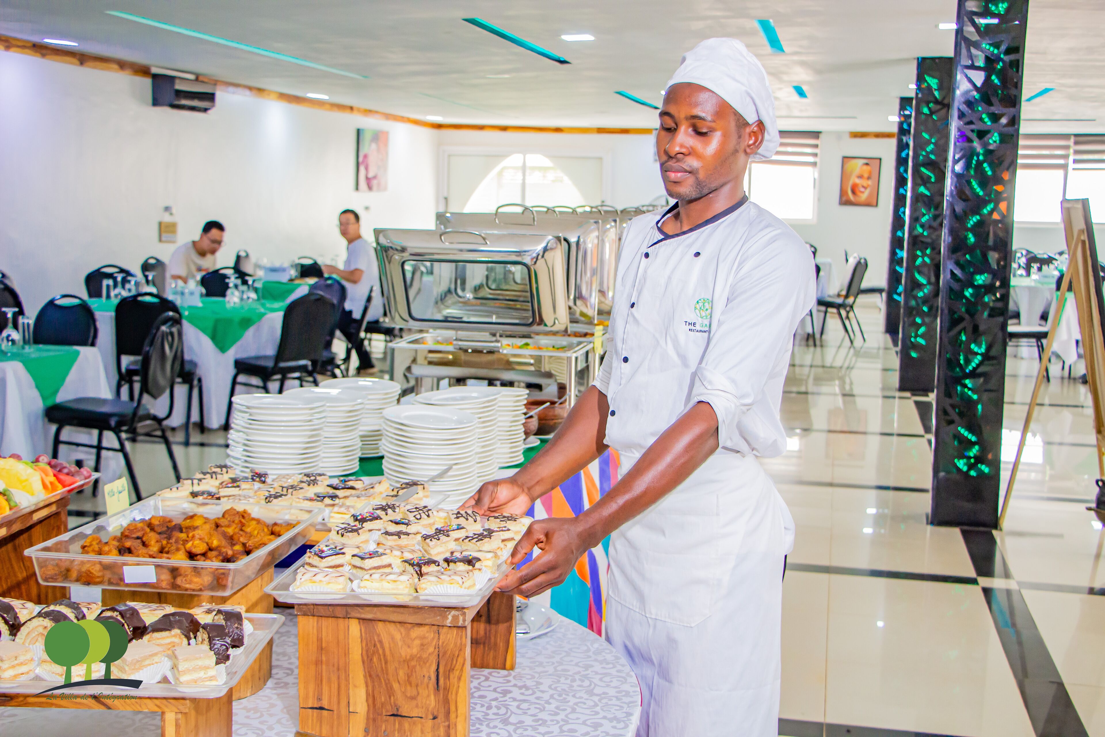 A buffet setup with various food items and a person serving.