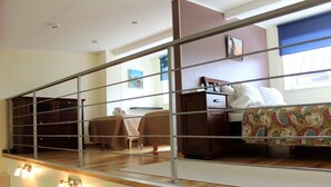 A bedroom with a bed, bedside table, and a window with a view. - Embrace Guestrooms & Apartments (Parnu)