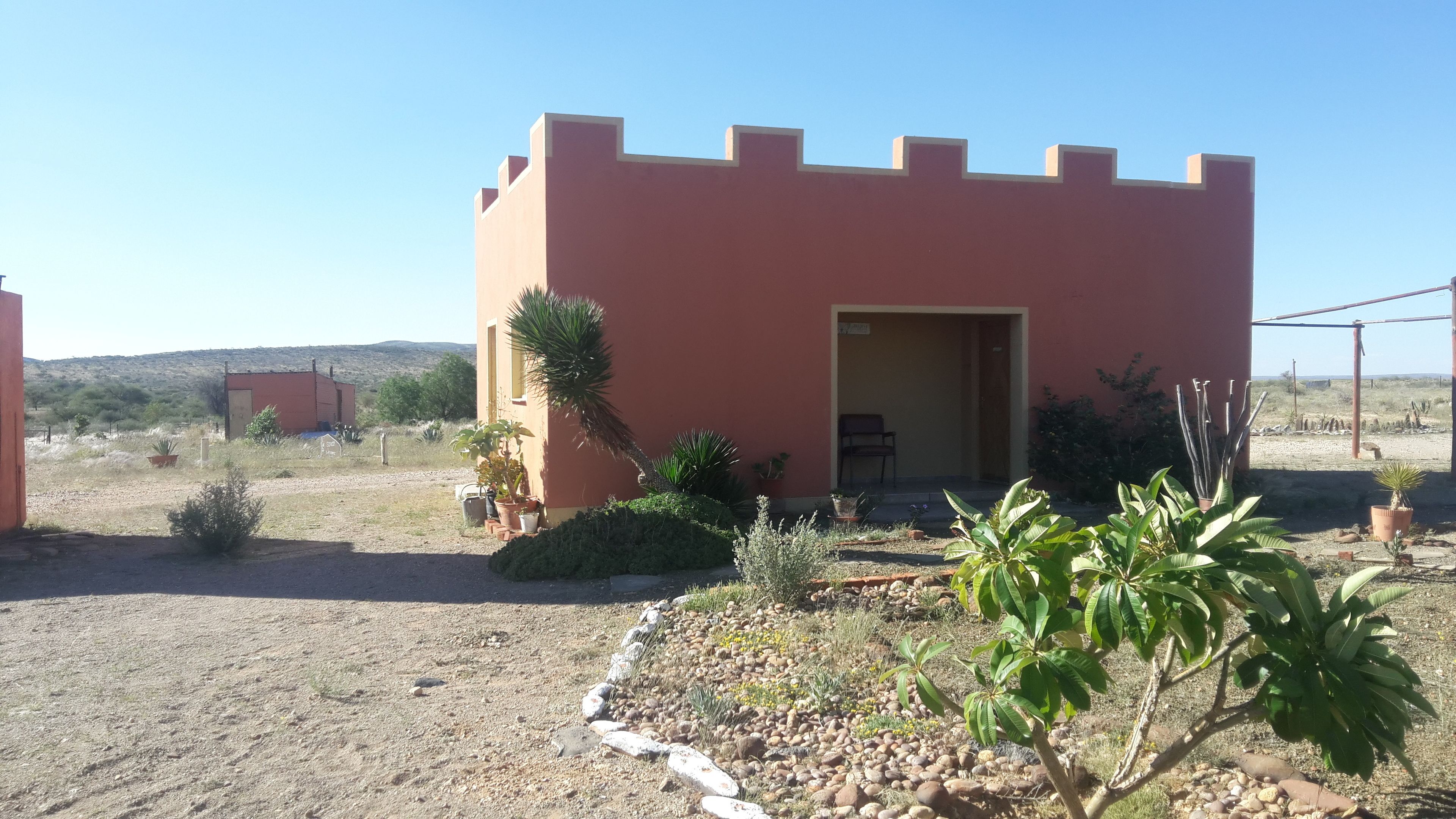 A small, single-story building with a flat roof and a door leading to an interior space.