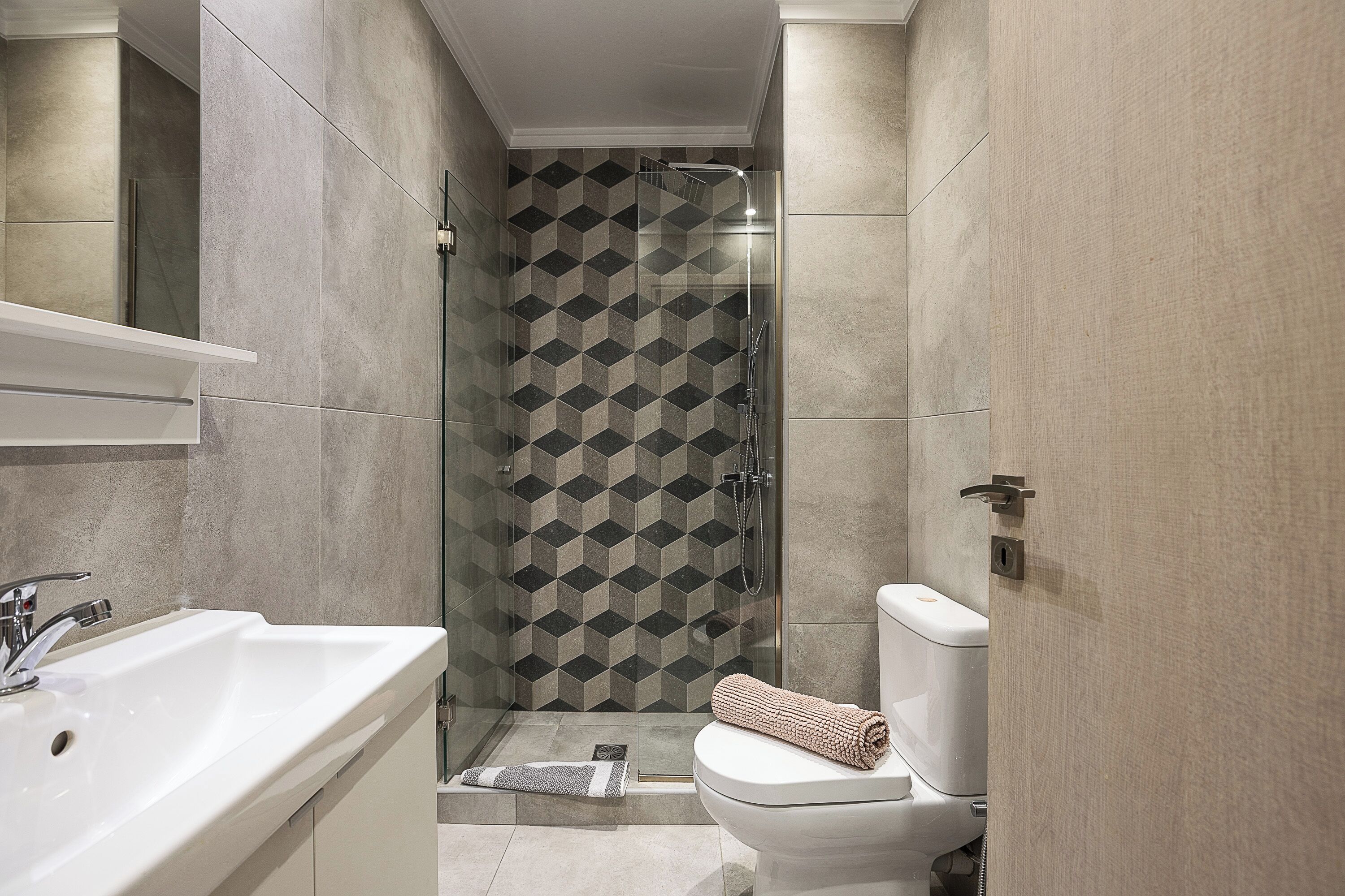Une salle de bain moderne équipée d’une douche, de toilettes et d’un lavabo.