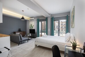 A modern hotel room with a bed, desk, and seating area. - The Omnia Collection Pagrati (Athens)