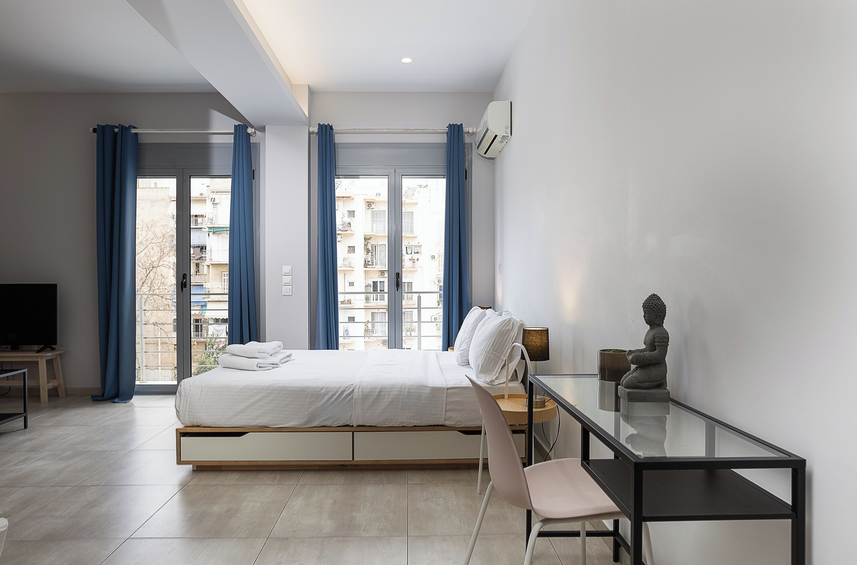 A modern bedroom with a bed, a desk, and a chair.