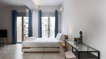 A modern bedroom with a bed, a desk, and a chair.