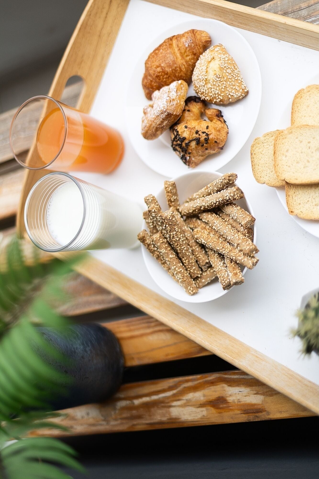 A tray with food items including bread, pastries, and a glass of orange juice.