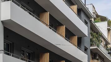 Un immeuble à plusieurs étages doté de balcons, de grandes fenêtres et d’une devanture avec une enseigne.
