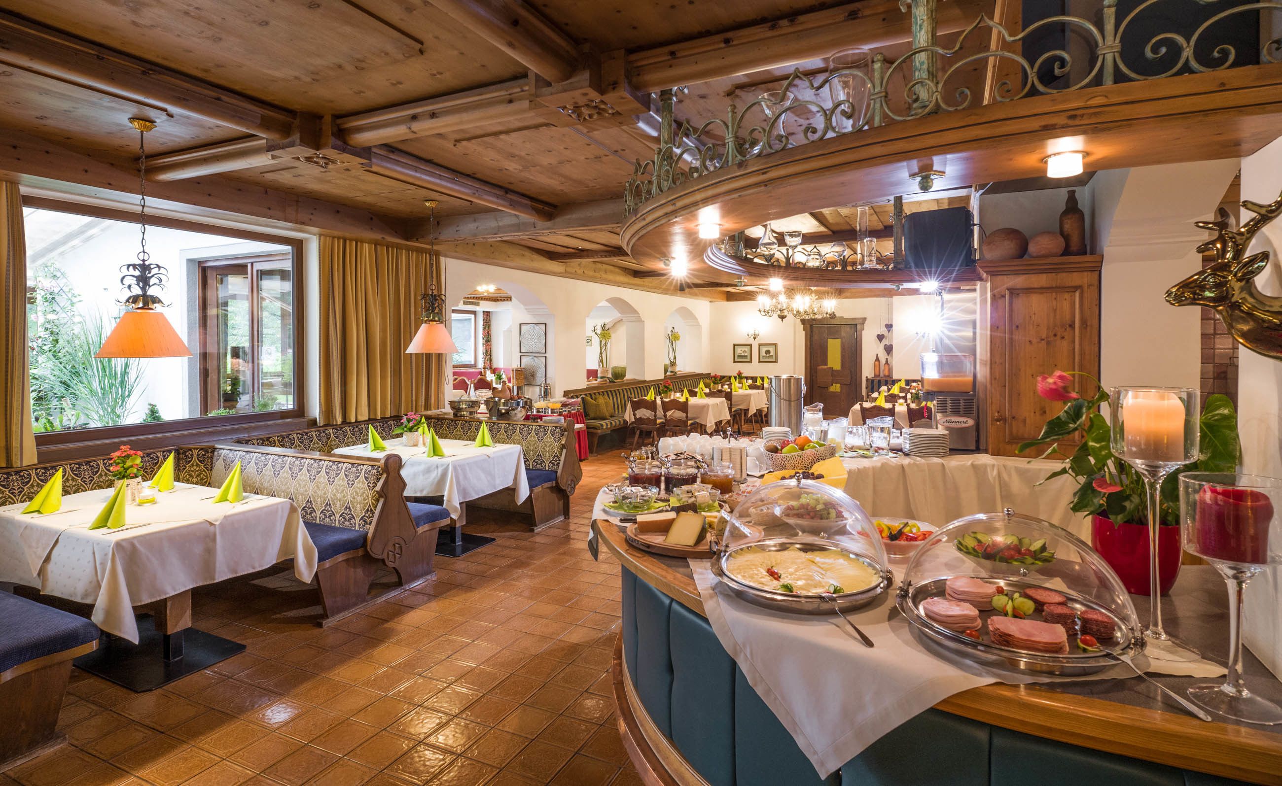 Un restaurant au décor intérieur en bois, doté de nombreuses tables et d’un espace buffet proposant une variété de plats.