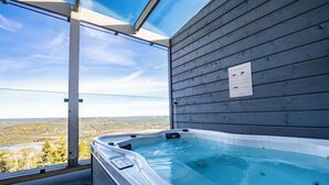 Un bain à remous offrant une vue dégagée sur un paysage montagneux grâce à une grande fenêtre.