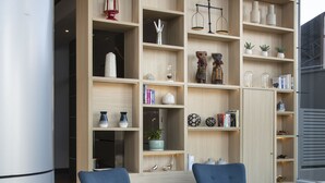 A modern lounge area with seating and a bookshelf.