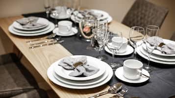 A neatly set dining table with plates, glasses, and cutlery.