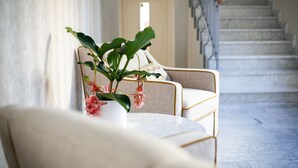 Un interior modern amb una escala, una planta en test i una cadira.