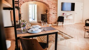 Una zona de menjador amb un arc de maó, un televisor fixat a la paret i un disseny interior modern.