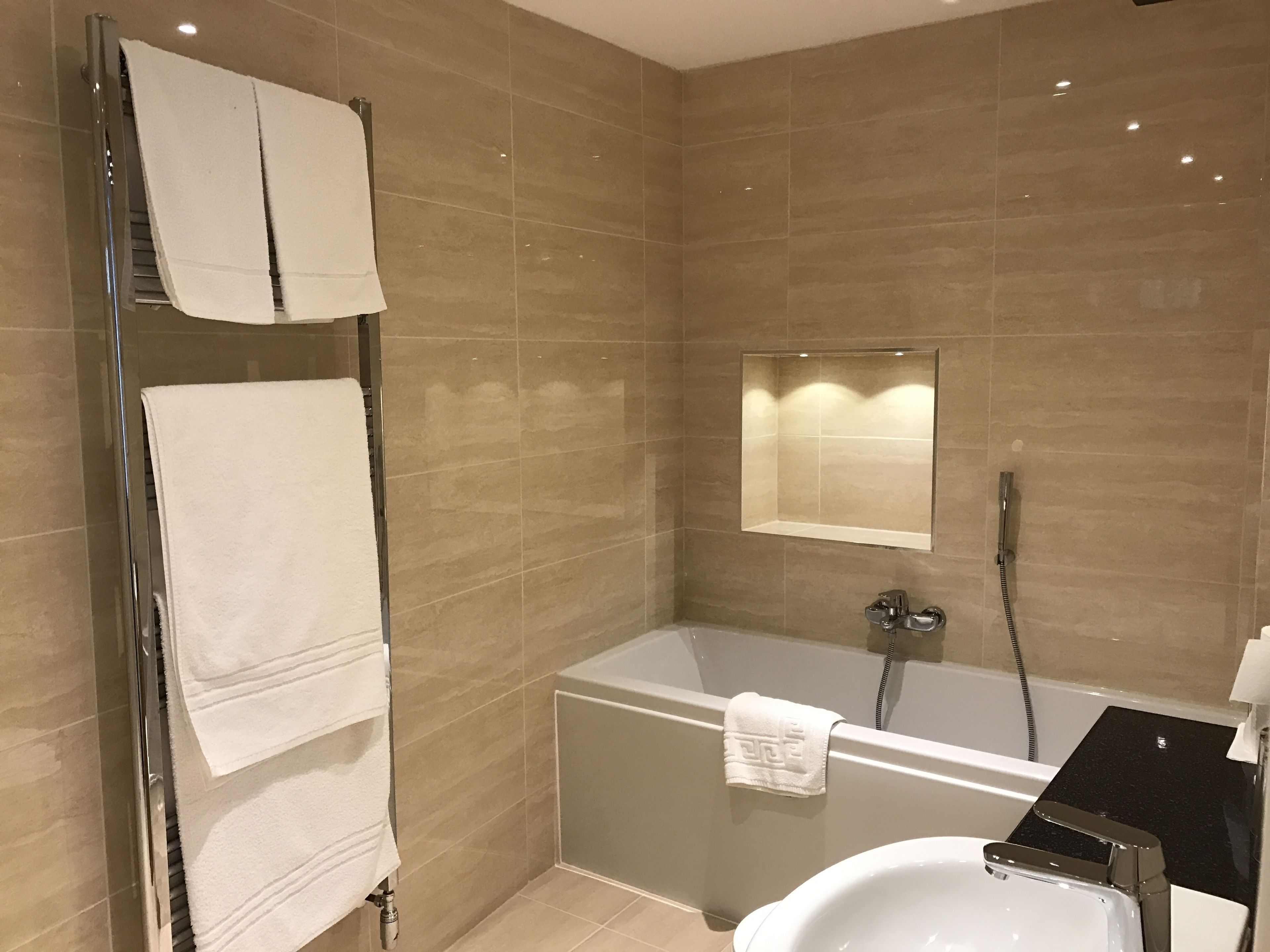 A modern bathroom with a bathtub, a glass shower enclosure, and a sink.