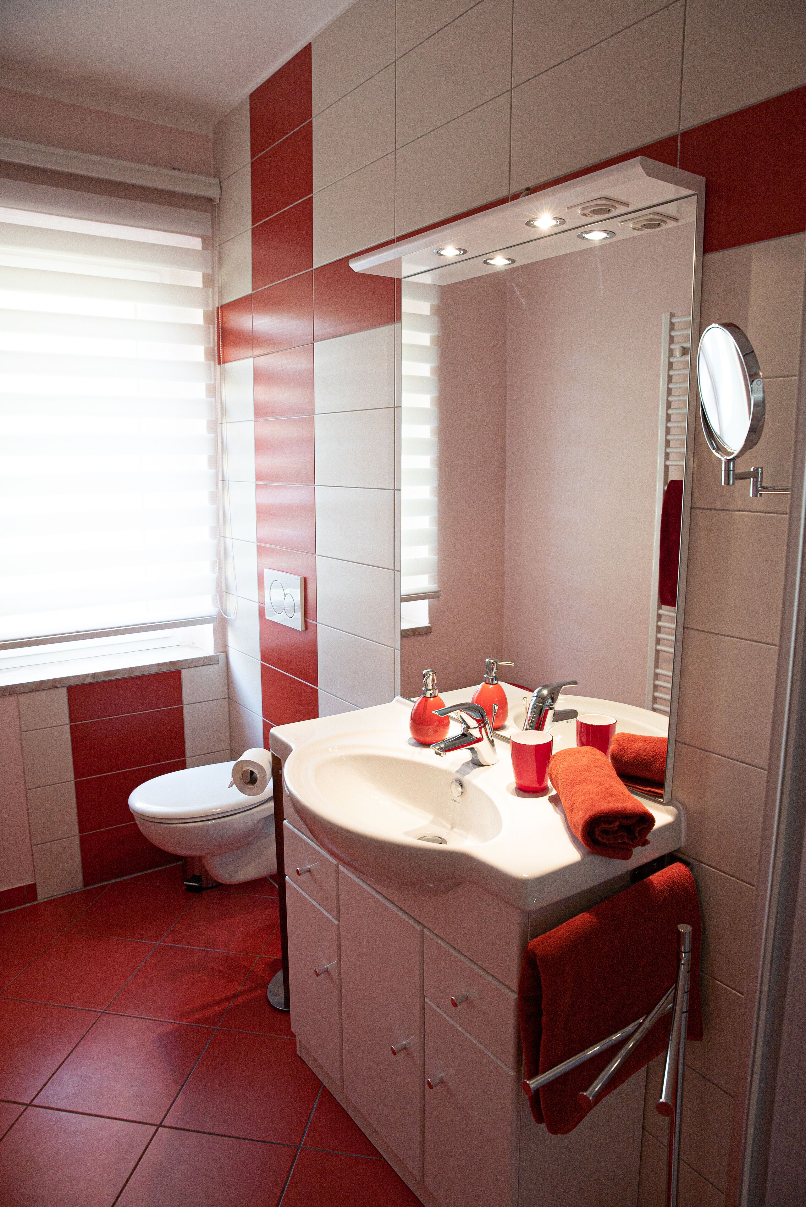 A bathroom with a toilet, sink, and mirror.