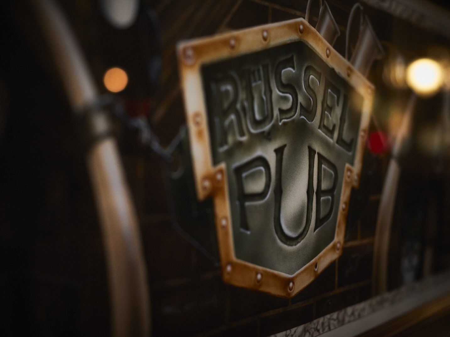 A sign for 'RUSSEL PUB' with a hexagonal shape and riveted edges.