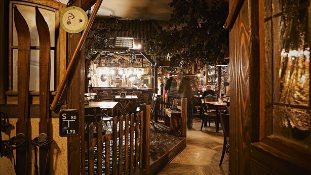 A cozy, rustic bar area with wooden decor and a clock on the wall. - Restaurant & Pension Rüssel - Pub (Sangerhausen)