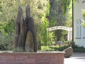 A stone sculpture in a landscaped area with a sign reading "Biergarten". - Montana Hotel Kassel-Süd (Guxhagen)