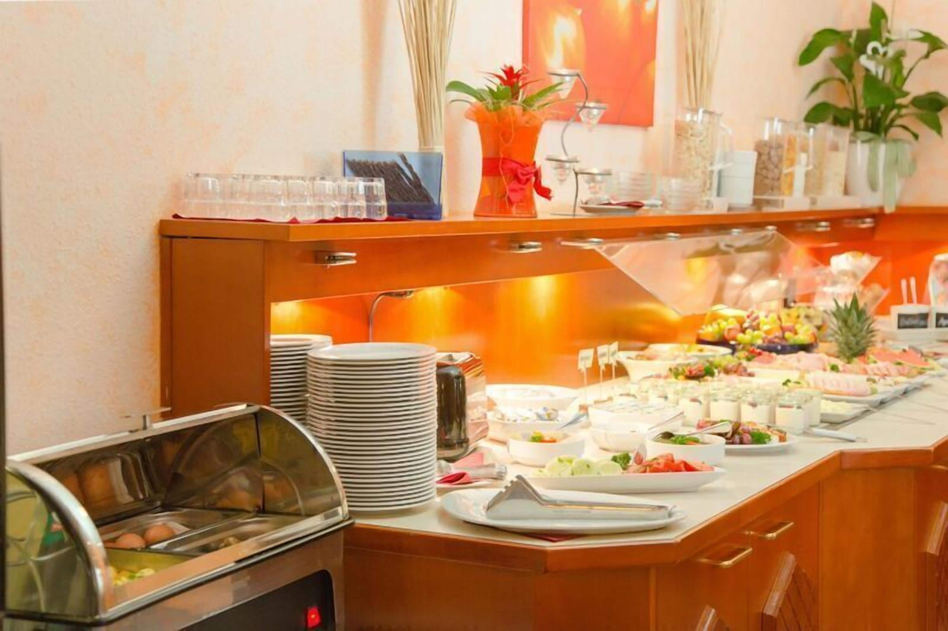 A buffet setup with various food items and a fruit display.