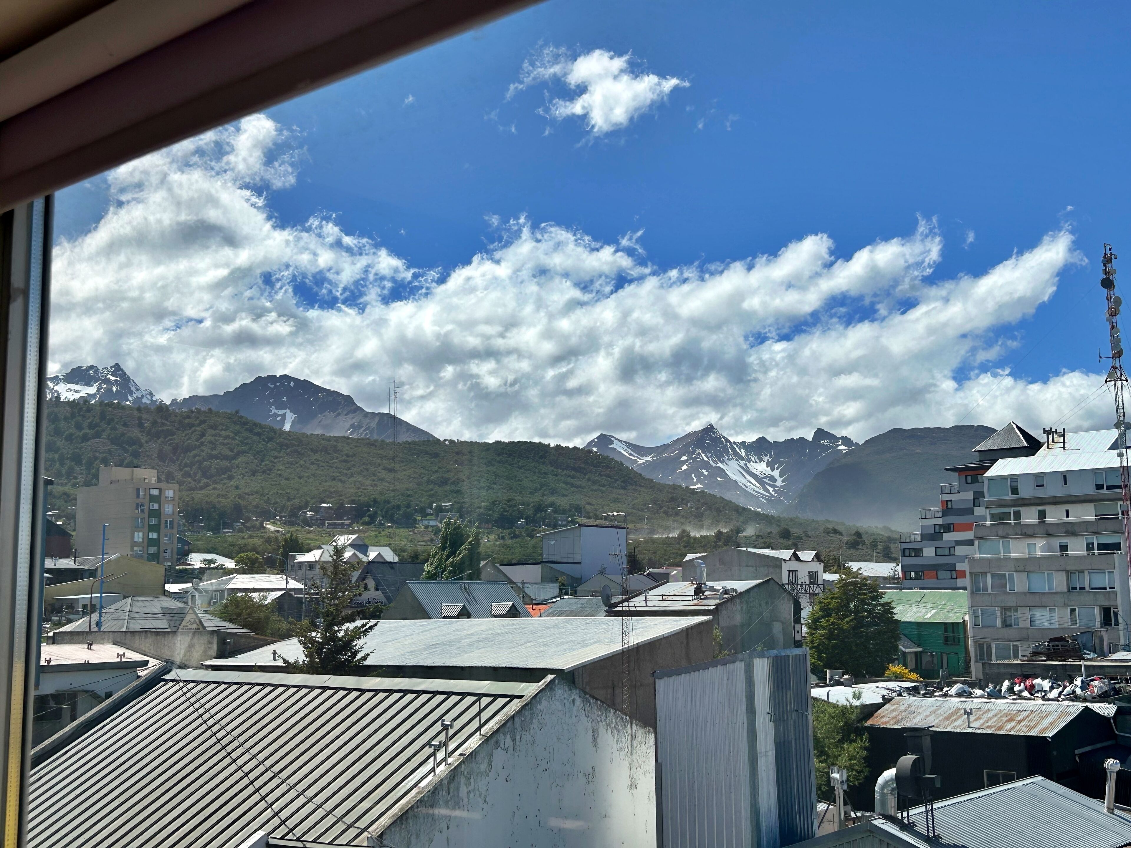 Une vue d’un paysage montagneux, avec des bâtiments au premier plan.