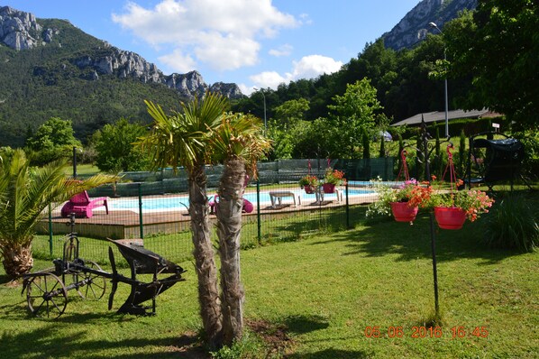Una piscina al aire libre de temporada, sombrillas