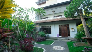 A two-story building with a garden in front. - Akusara Guest House (Ubud)