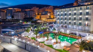 Un hotel con piscina, mobiliario exterior y vistas de los edificios circundantes.