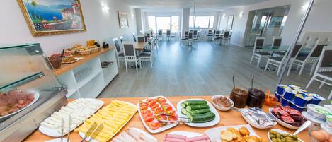 A buffet area with various food items and a large window in the background.