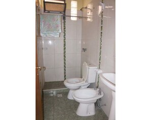 Tina con regadera, regadera tipo lluvia, bidet, toallas