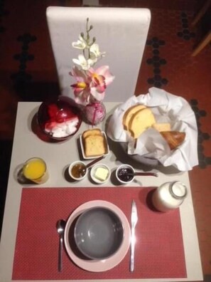 A breakfast setting with a plate of food, a vase of flowers, and a bottle of milk. - Le Domaine de Regnonval (Blicourt)