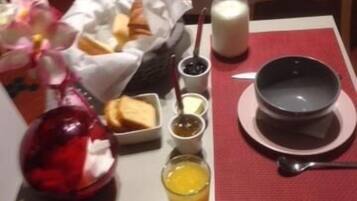 A breakfast table with a bowl, a glass of orange juice, a bottle of milk, and a plate of toast.
