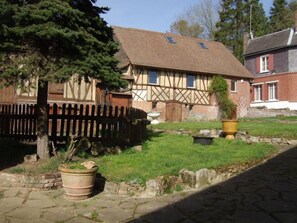 A traditional half-timbered house with a thatched roof, a wooden fence, and a stone pathway leading to the entrance. - Le Domaine de Regnonval (Blicourt)