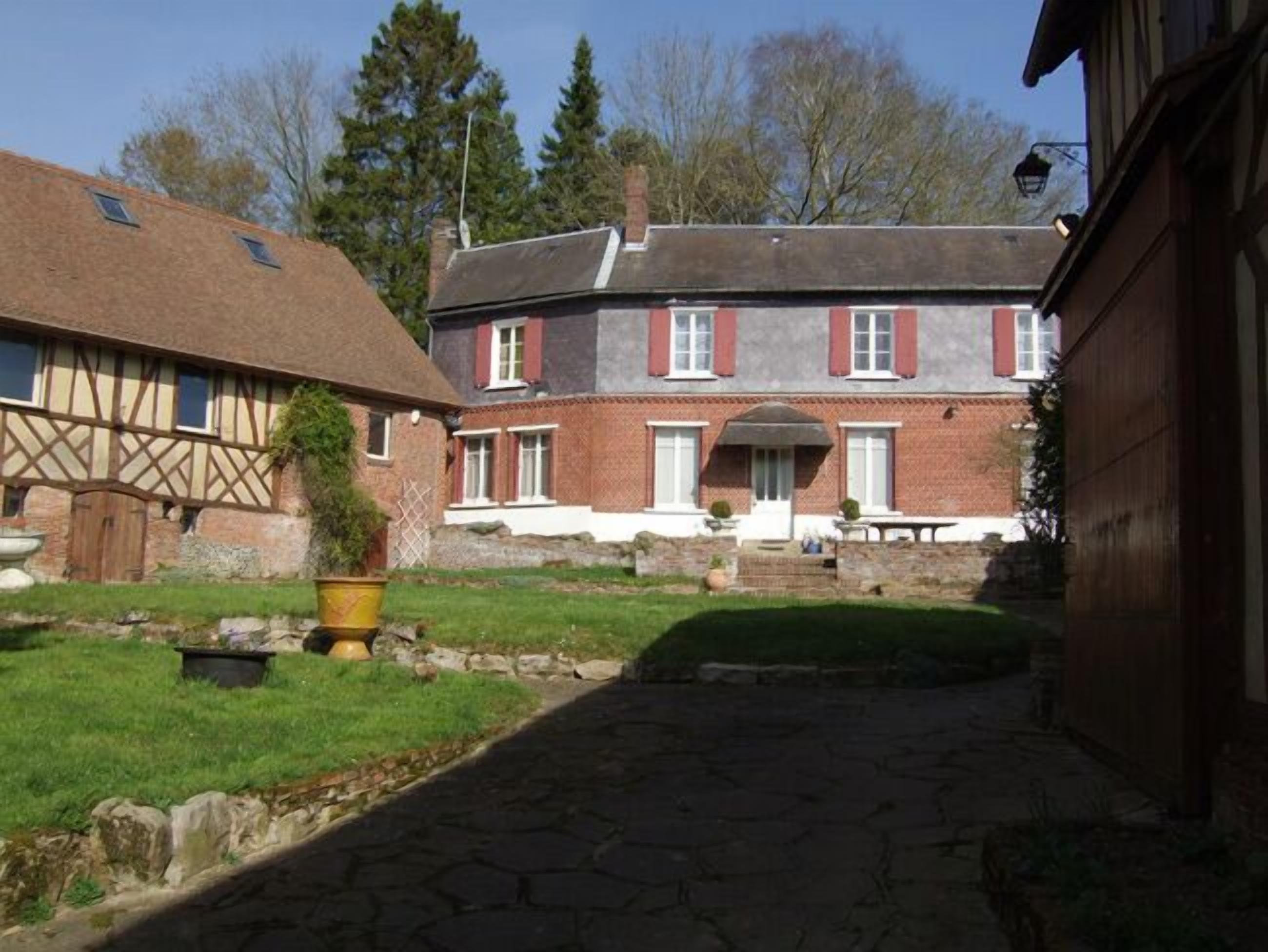 A traditional brick house with a stone pathway leading to a wooden door.