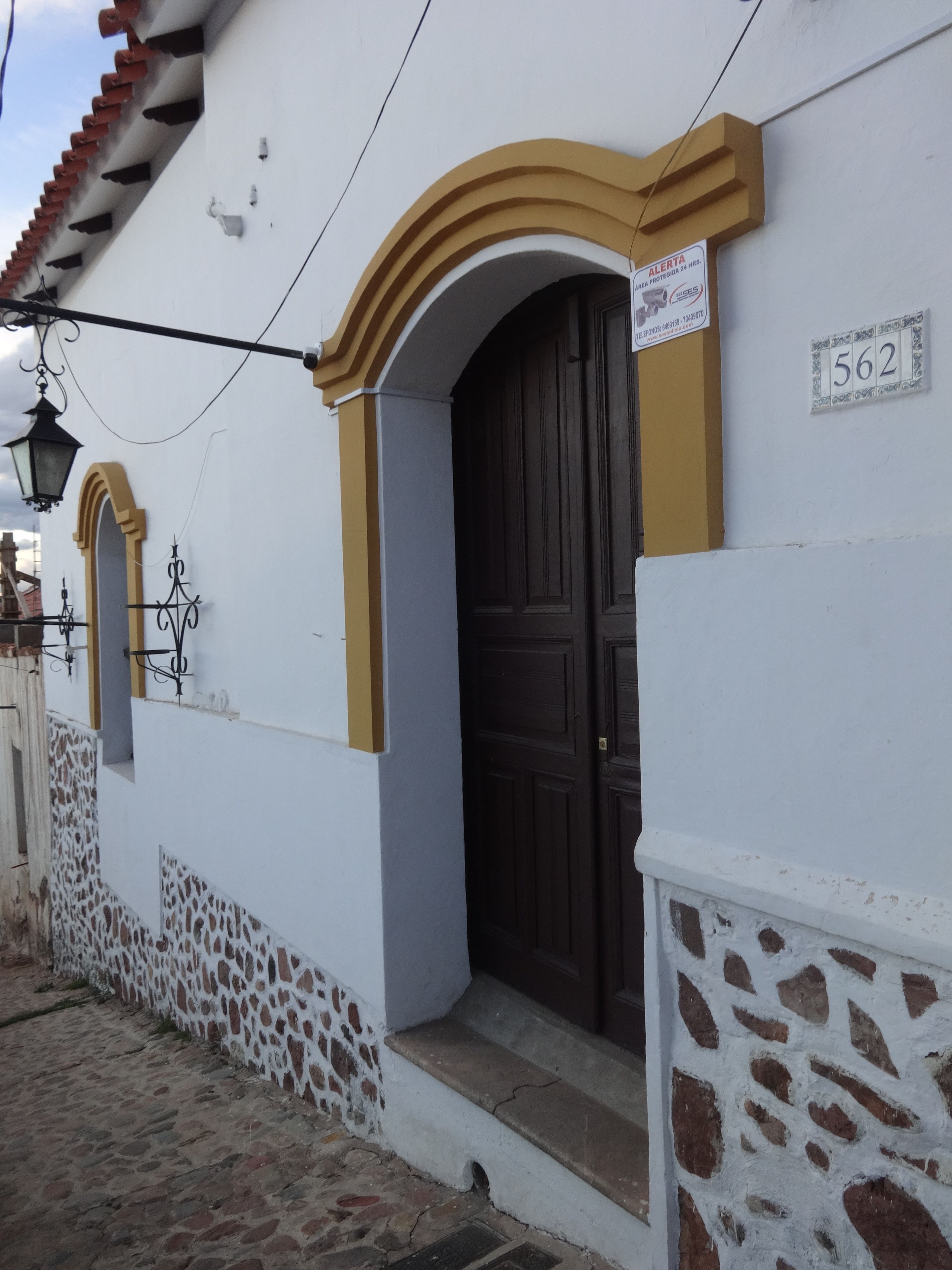 Un edificio blanco con una puerta marrón y un cartel con el número 562.