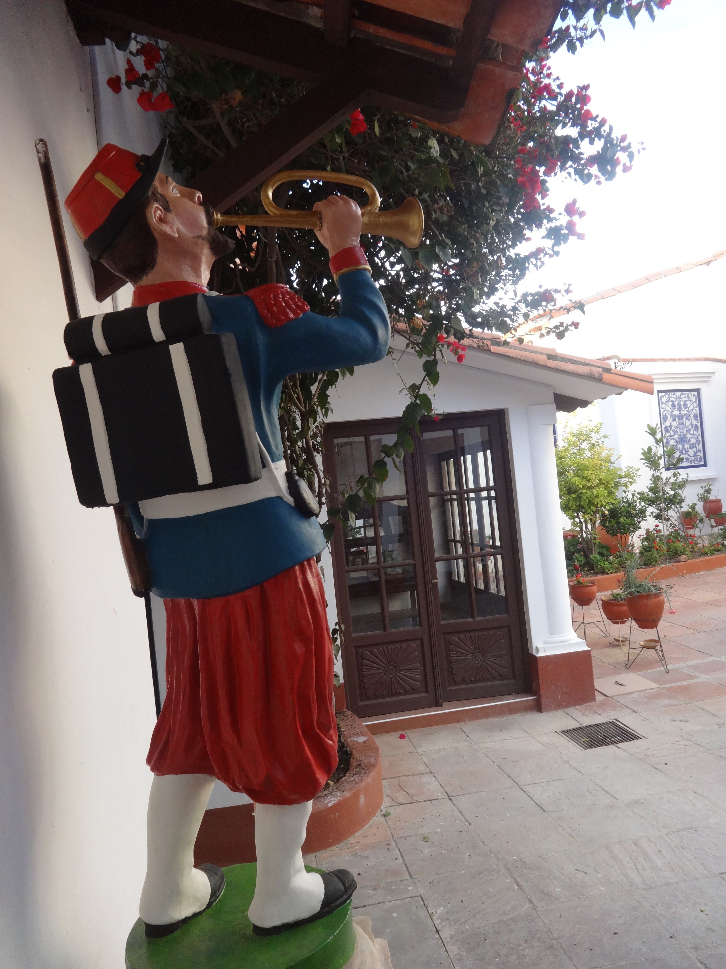 A statue of a man playing a trumpet, positioned on a green base.
