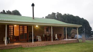 A brick building with a green roof and a covered porch.