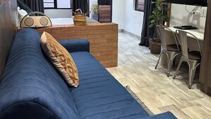 Una sala de estar moderna con un sofá azul, una mesa de centro y un televisor.