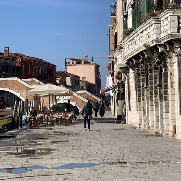 A street with buildings, outdoor seating, and a few people walking. - Royal Guest House Venice (Venice)