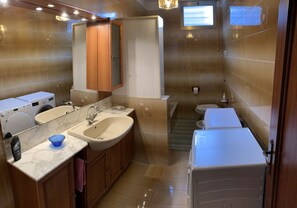 A compact bathroom with a sink, mirror, and two washing machines. - Royal Guest House Venice (Venice)