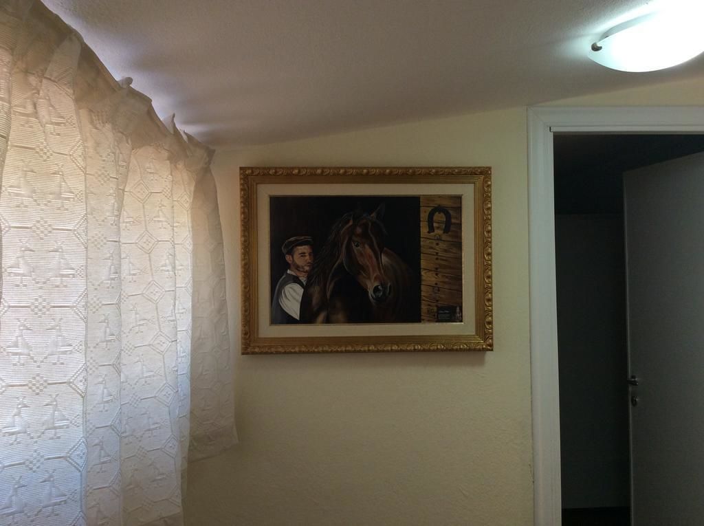 Un cuadro enmarco que muestra a un hombre y un caballo en una pared.