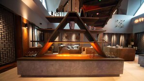 A modern interior with a central seating area, a fireplace, and a decorative sculpture. - Cave Hotel & Golf Resort (Faversham)