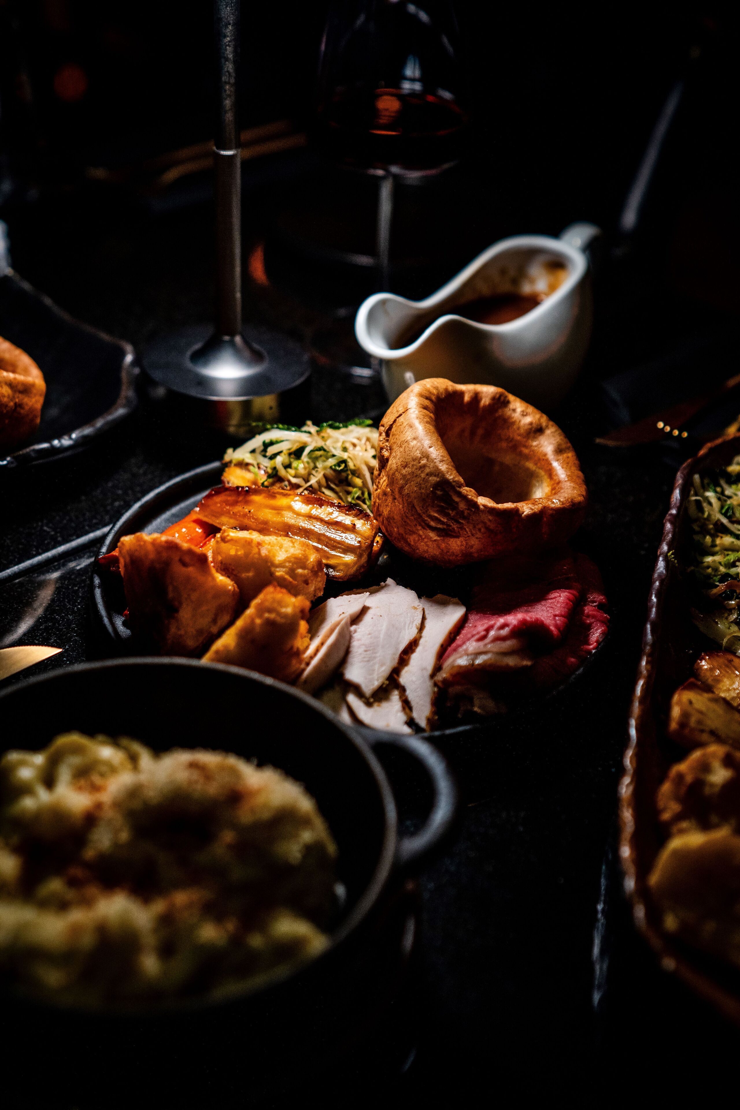 Ein Tisch mit verschiedenen Gerichten, darunter Yorkshire Pudding, gebratenem Fleisch und Gemüse.