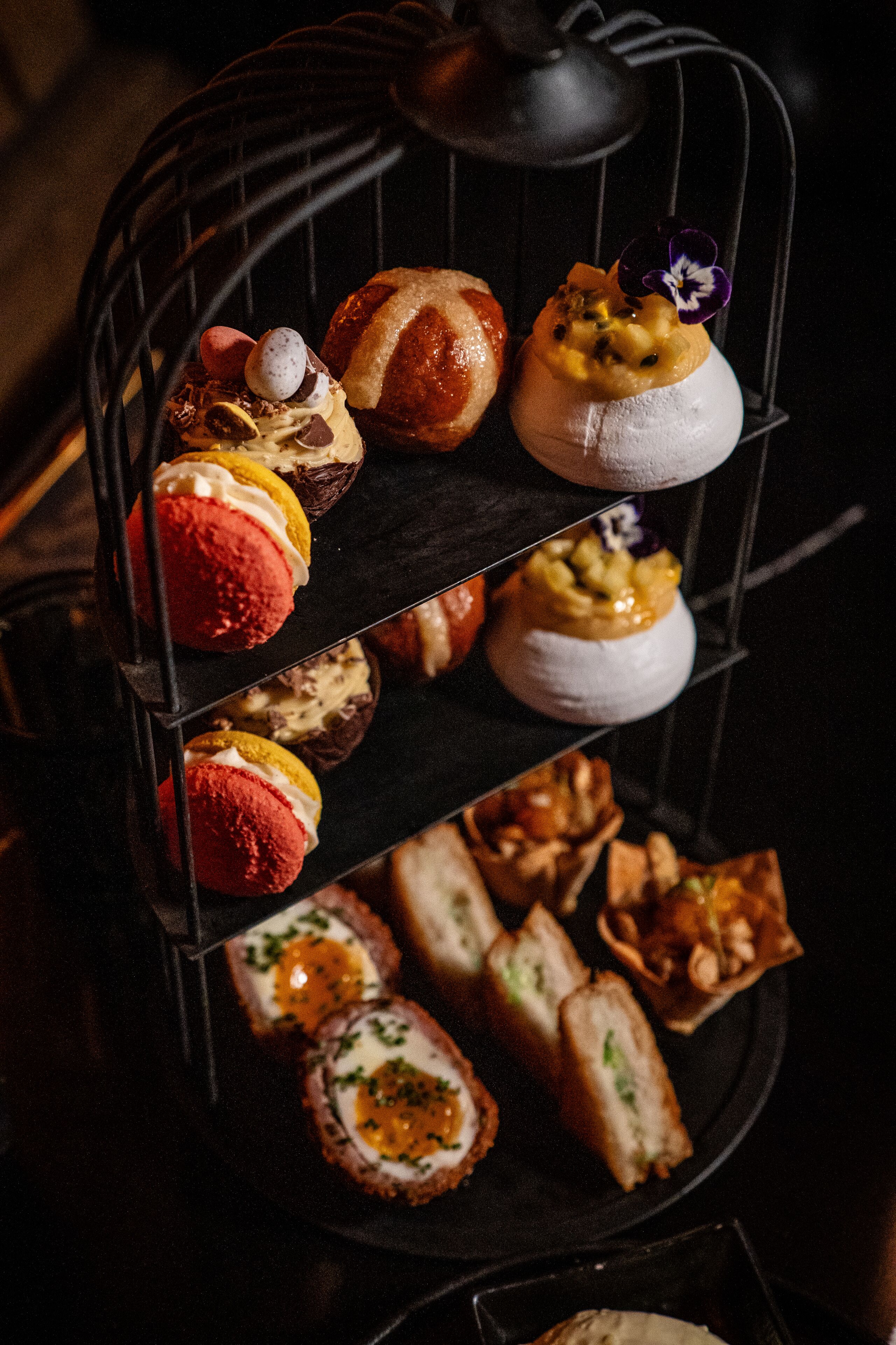 Una bandeja escalonada con diversos pasteles y postres.