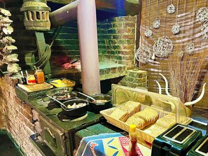 A kitchen with various food items, utensils, and a bread basket. - Roy's Rest Camp (Grootfontein)