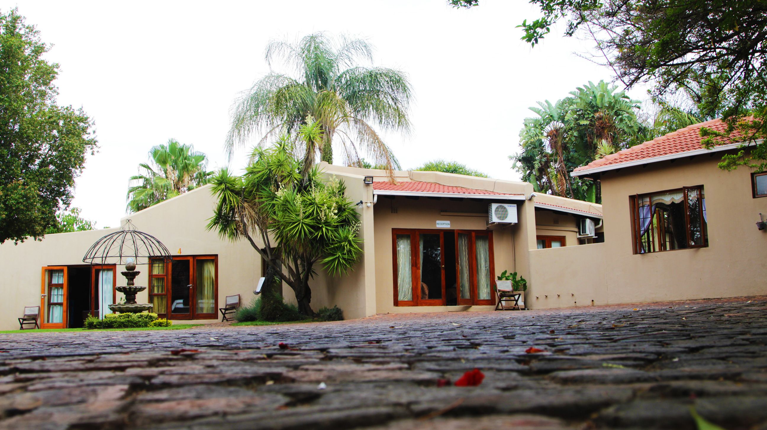 A building with a reception area, a fountain, and a cobblestone courtyard.