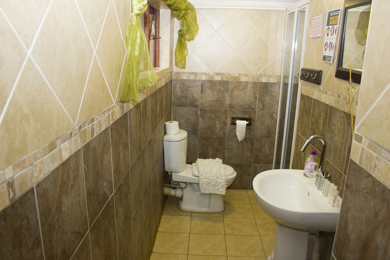 A bathroom with a toilet, sink, and shower.