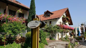 Segno di un hotel con un design tradizionale, immerso nel verde e tra piante fiorite.