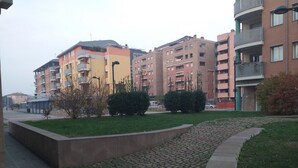 A residential area with multi-story buildings, a paved pathway, and small green spaces. - B&B San Vitale (Bologna)