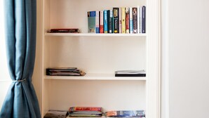 Uma estante branca com livros e objetos decorativos.
