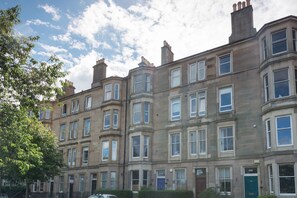 A row of traditional terraced houses with uniform window designs and a brick facade. - Beautiful City Center 2 Bed Apartment with Park View (Edinburgh)
