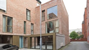 A modern brick building with large windows and a car parked in front. - Double Penthouse en suite - hiphipstay (Dublin)