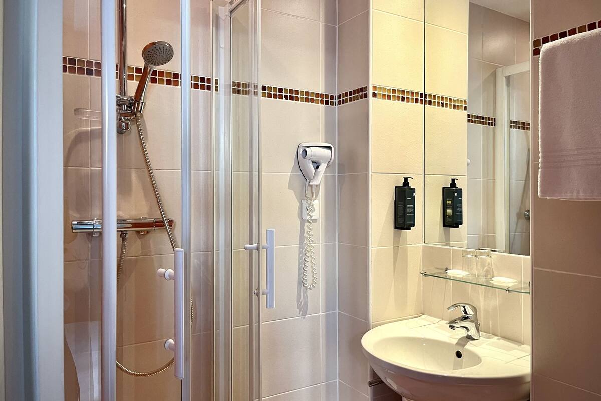 standard single room | bathroom | separate bathtub and shower, towels, soap, shampoo